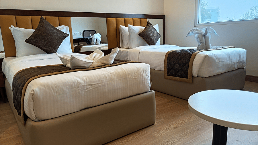 Bedroom with twin beds and a table in centre-  Quality Inn Rockwell Grand