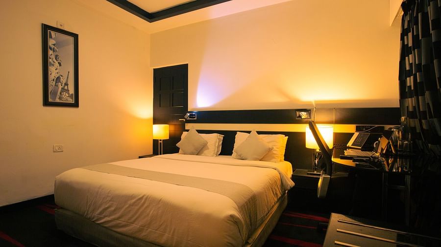 Premium AC room at the Pearl Hotel with a double bed and a wardrobe