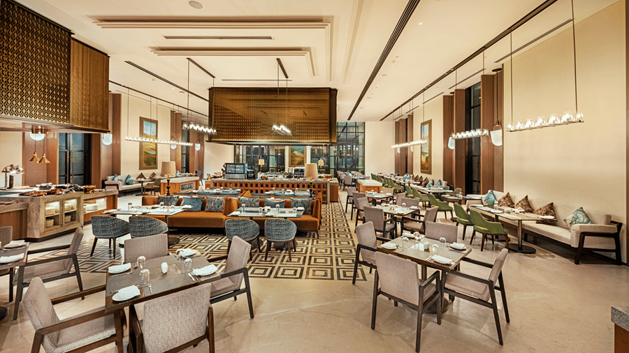 Restaurant seating area with wicker chairs and a bold patterned floor at Chithirai restaurant, The Residency Signature Madurai