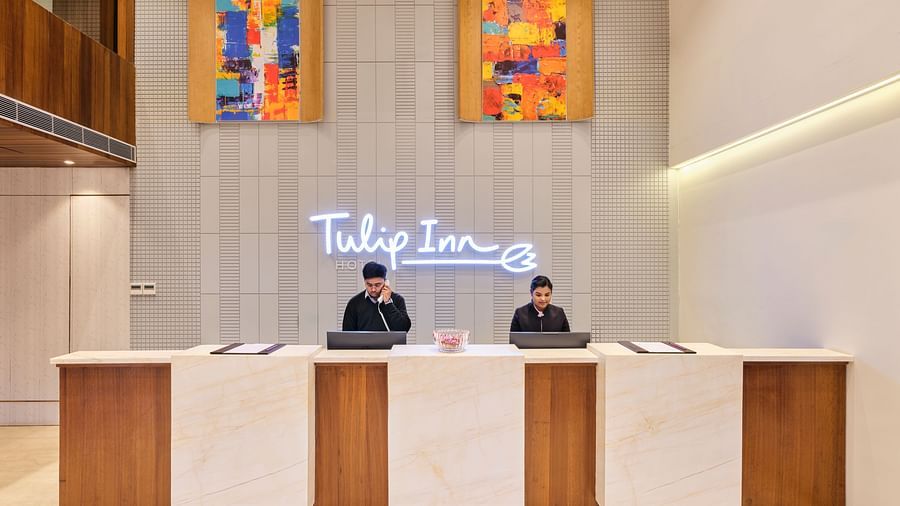 Image of a hotel lobby featuring a reception desk with two people standing behind it at Tulip Inn, Bhopal.