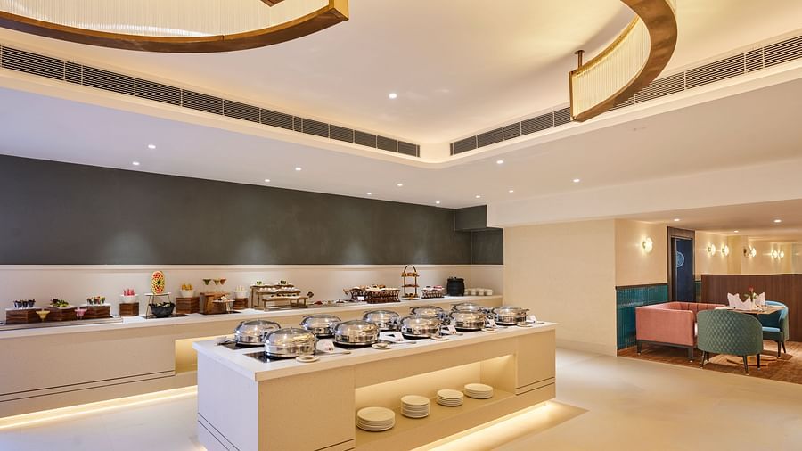 An image of a restaurant in Bhopal featuring a buffet table with an array of food displayed on the countertop at  Tulip Inn, Bhopal.