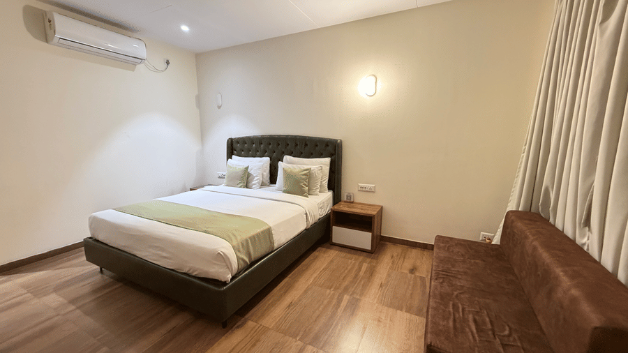 Modern hotel cottage room with a large bed and wooden accents at  VITS Daman Devka Beach