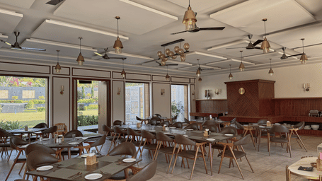 A restaurant dining hall featuring wooden tables, chairs, ceiling fans, and open glass doors leading outside at Bindiga Peak Resort.