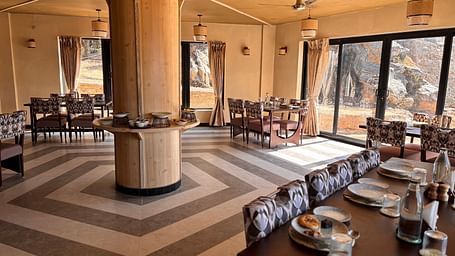 A dining area at The Chamomile Estate with tables and chairs set atop a patterned floor.