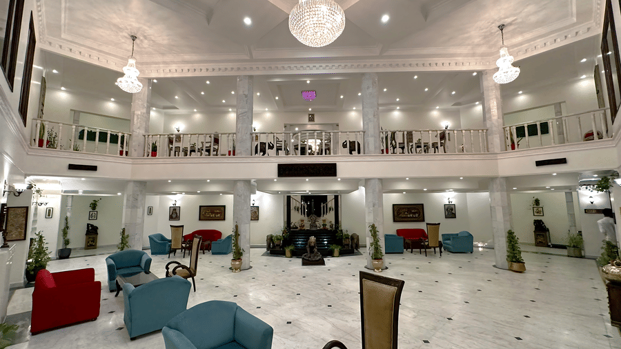 A lobby with sofas, chairs, and a chandelier at AS Hotels, Khajuraho.