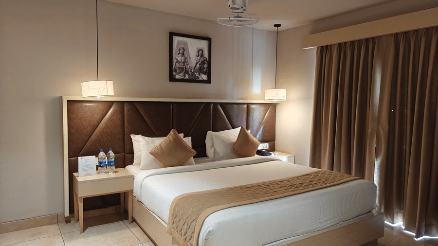 Well-designed Deluxe Double Room at Cholaa Dynasty, Kumbakonam with modern interiors, comfortable bedding, bedside lighting, and refined décor creating a welcoming space for travellers seeking a pleasant stay in Kumbakonam
