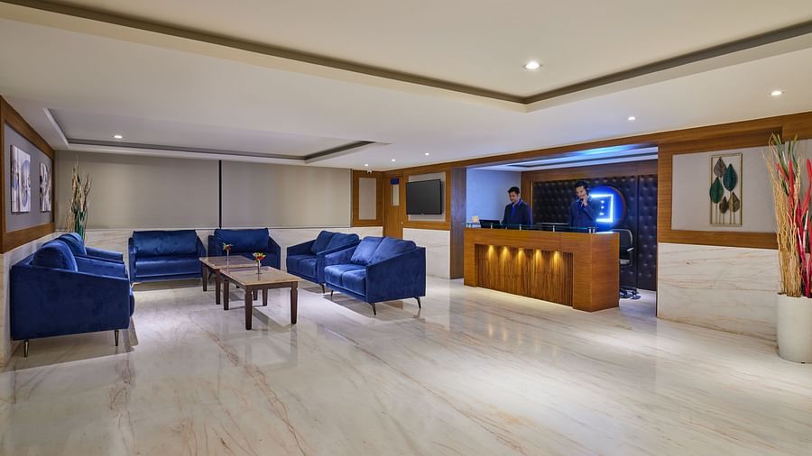 Well-lit lobby area of Essentia Premier Hotel, Chennai with sofa seating and a coffee table