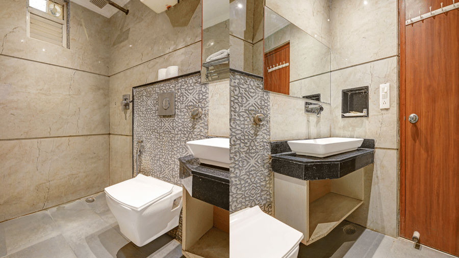 Clean and contemporary bathroom with a white floating toilet and marble wall tiles - Hotel Velocity