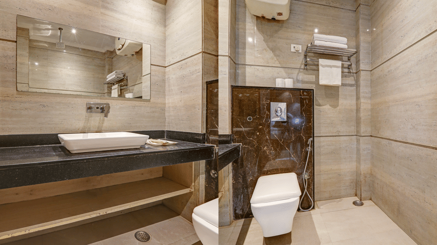 Sleek bathroom featuring a vessel sink, large mirror, and wall-mounted water heater - Hotel Velocity