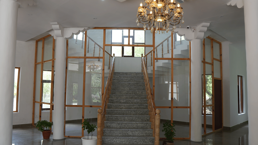 A space with chandelier, stairs, and multiple pillars |  Indus Serinity, Leh Ladakh