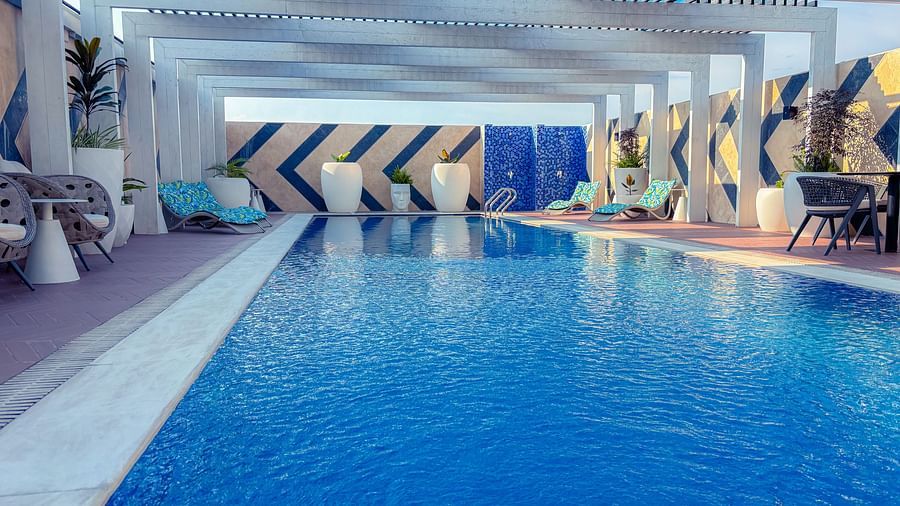 Swimming Pool at KertelSuites, featuring crystal-clear water under the open rooftop sky, with lounge chairs