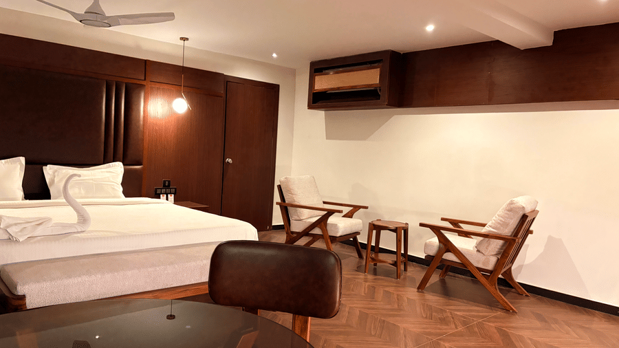 Side view of the bed showing the large window and natural light - Lords Riverside Resort, Muduba - Shivamogga