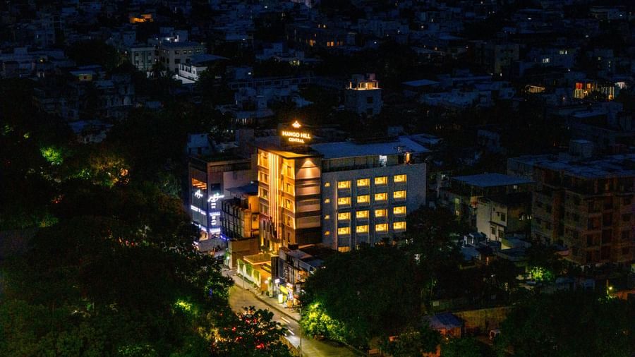 An aerial night view of Mango Hill Central, Chennai, showing the illuminated hotel building surrounded by other buildings.