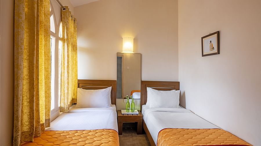An image of two single beds placaced in a small room | Mango Hill, Kodaikanal