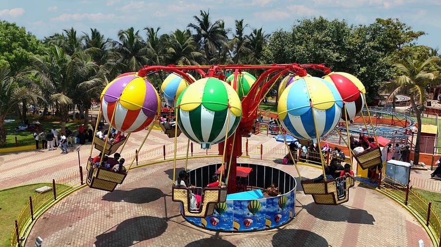 A balloon race ride featuring seven balloons and below it there are seats. The seven balloon rotates under the influence of a machine at the bottom.