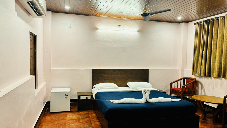 Standard room at Paradise Lagoon Resort, Udupi, featuring a double bed and a mini-refrigerator.