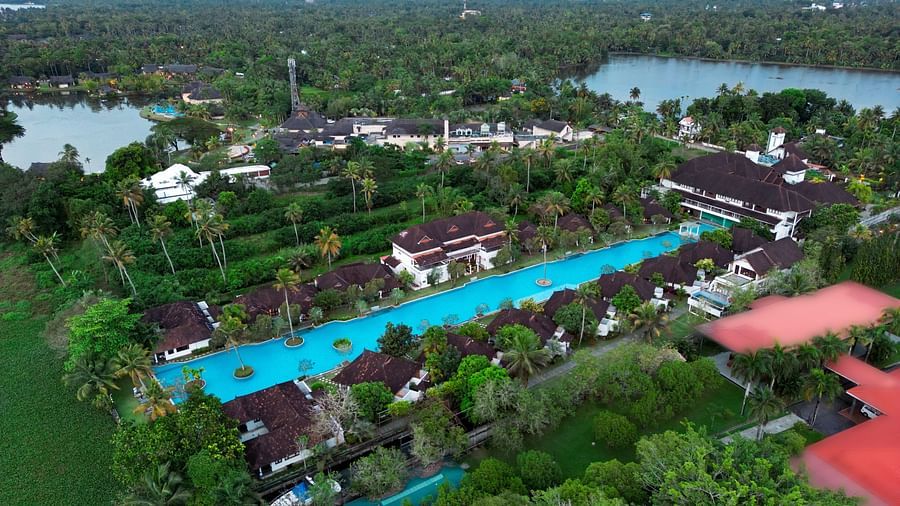 an aerial view of a swimming pool surrounded by rooms and trees - Rhythm Kumarakom.