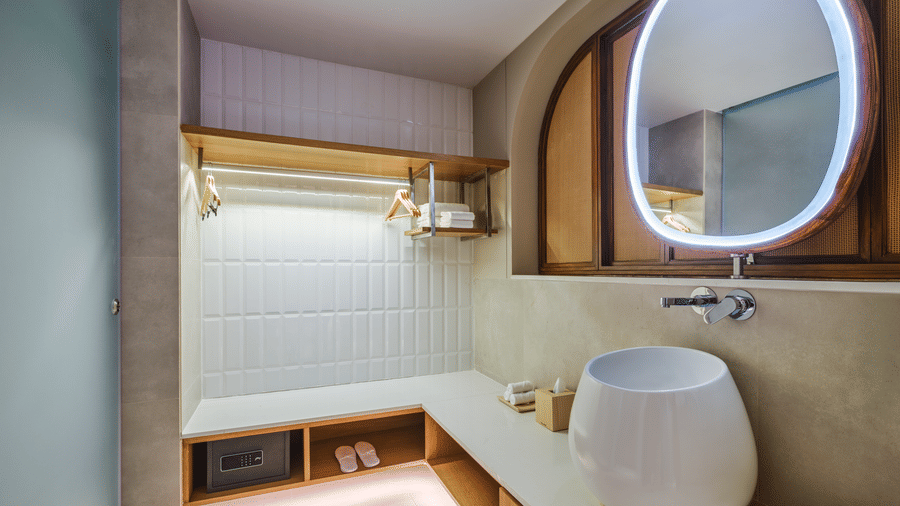The Premium Room bathroom at Swosti Premium Beach Resorts, Puri, with a sink, a mirror, and toileteries.