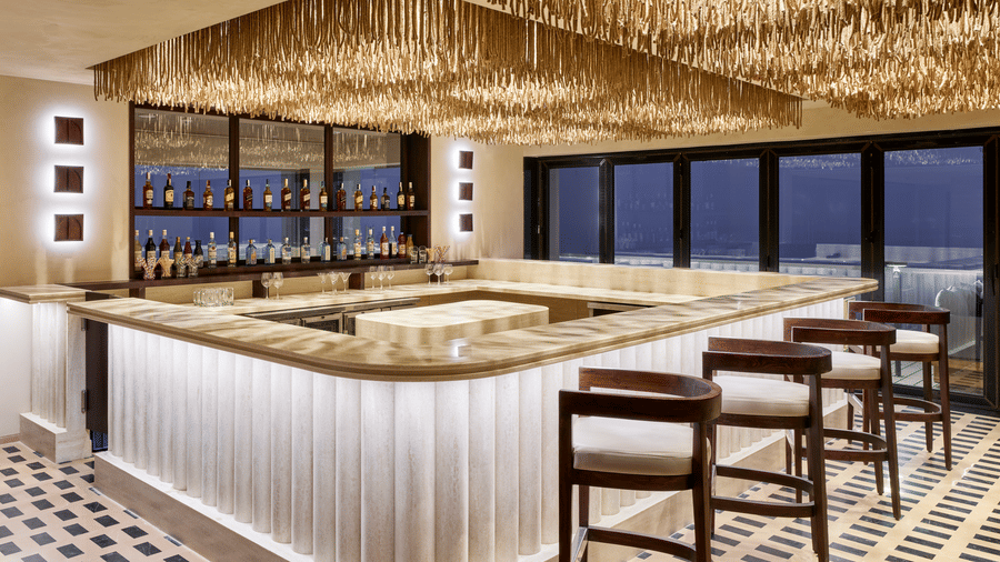 The Saltwater dining at Swosti Premium Beach Resorts, Puri, with a curved bar counter, high stools, and a distinctive thatched ceiling.