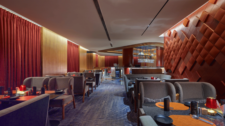 The well-lit bar of Swosti Premium, Bhubaneswar, with chairs, and tables arranged on the floor. 