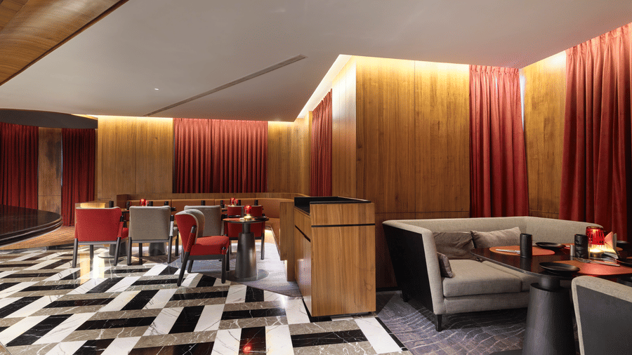 The well-lit bar of Swosti Premium, Bhubaneswar, with chairs, and tables arranged on a checkered floor. 