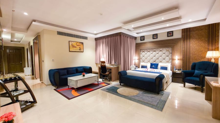 Full view of the Presidential Suite featuring the master bedroom along with a separate seating area in the corner at The Meriton.