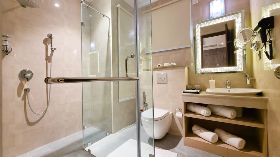A full-stacked vanity area in a bathroom at The Meriton with a separate shower cubicle separated by a glass door.