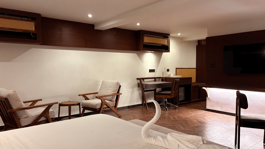 Front view of the king size bed with elegant dark wood headboard - Lords Riverside Resort, Muduba - Shivamogga