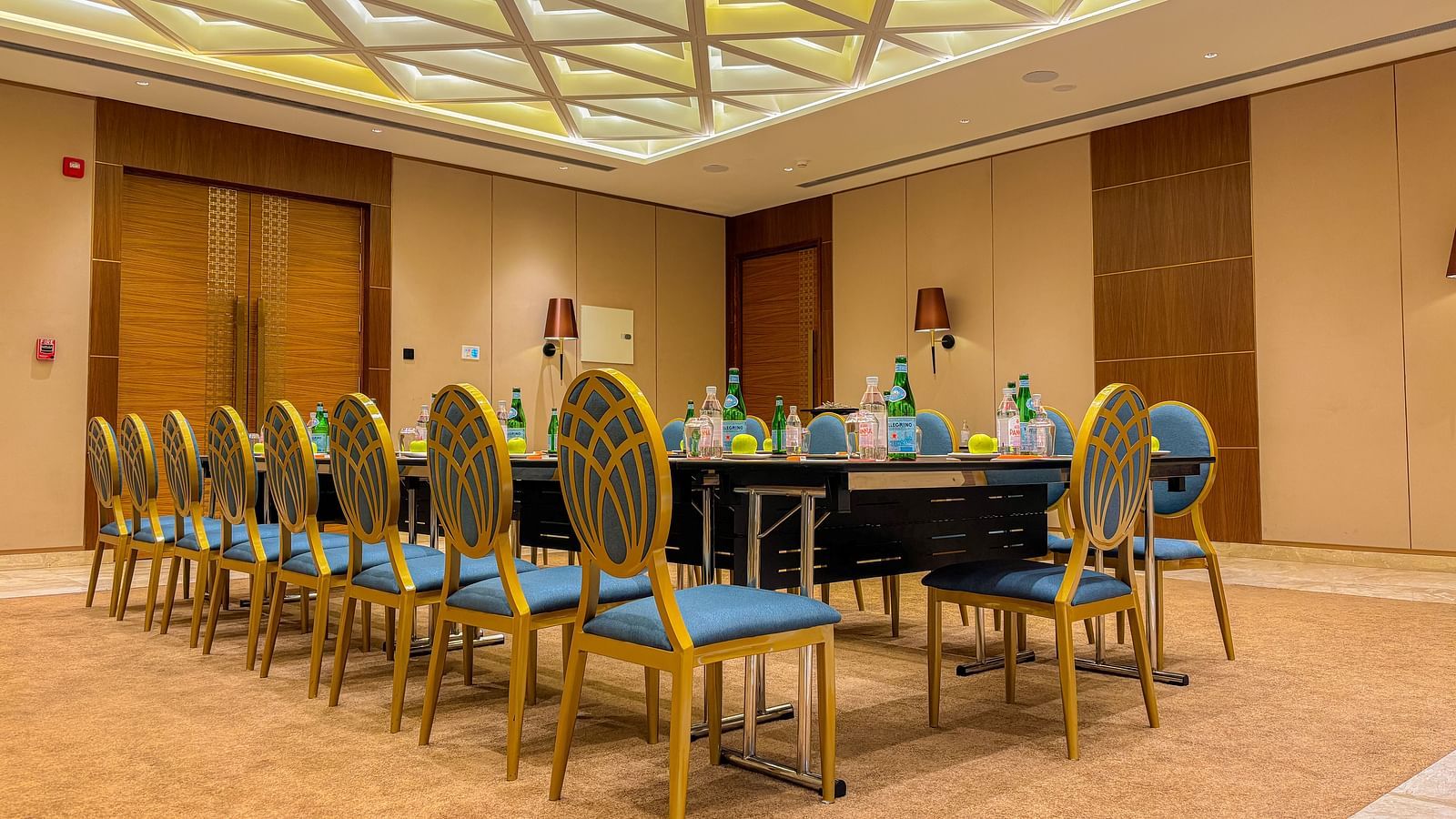Banquet Hall at KertelSuites, featuring a long table with elegant chairs, complemented by a stylish ceiling and ambient lighting