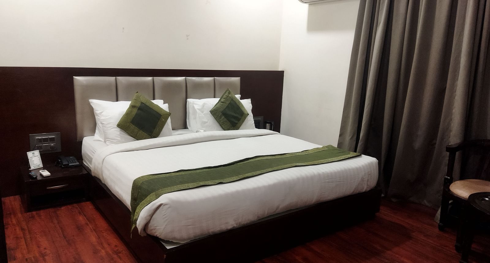 Another view of a hotel room with a green runner on the bed, a seating area - TGI Apple Inn, Jaipur 