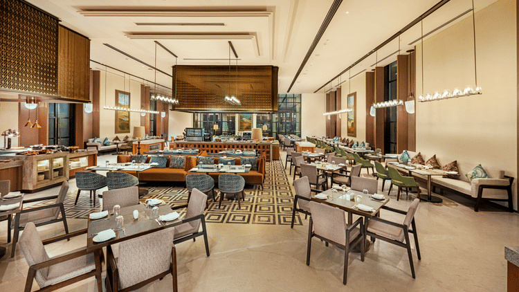 Wide view of CHITHIRAI restaurant at The Residency Signature Madurai with dining tables, wooden interiors, patterned flooring, and warm lighting.