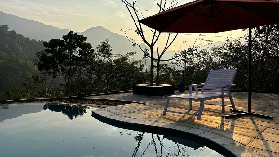 the swimming pool at Holistic Stay Eco Resort, Kannur featuring a sitout area overseeing the Brahmanagiri Mountains