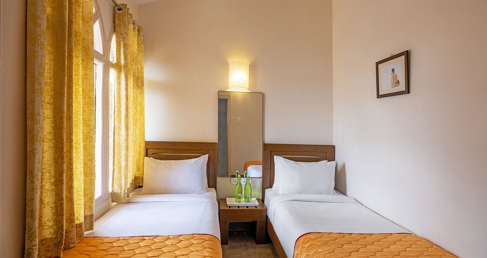 Villa bedroom with two twin beds and yellow curtains.