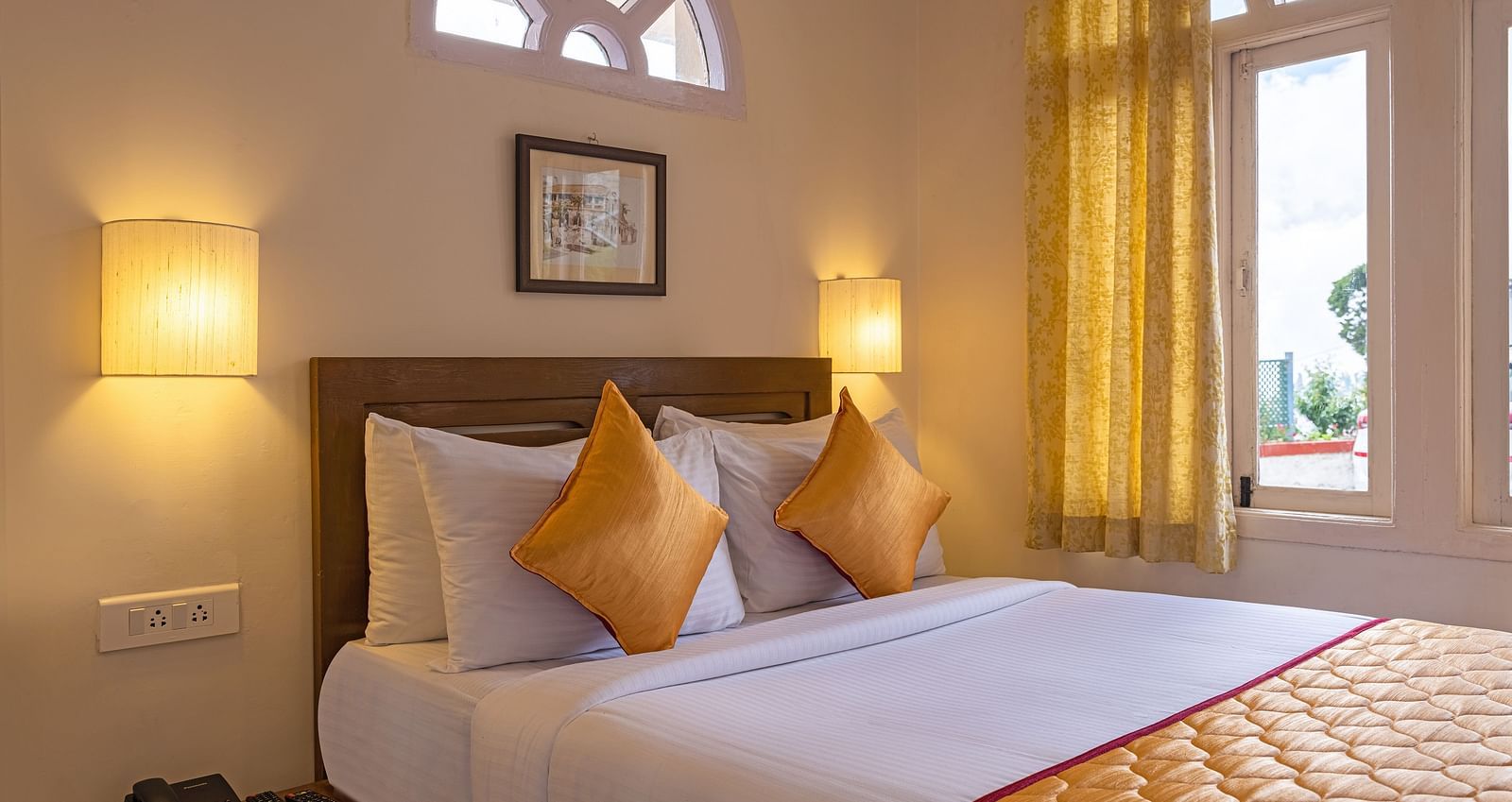 A cozy bedroom with with a small bed, a lamp at the bedside table, and a window where curtains are drawn | Mango Hill, Kodaikanal