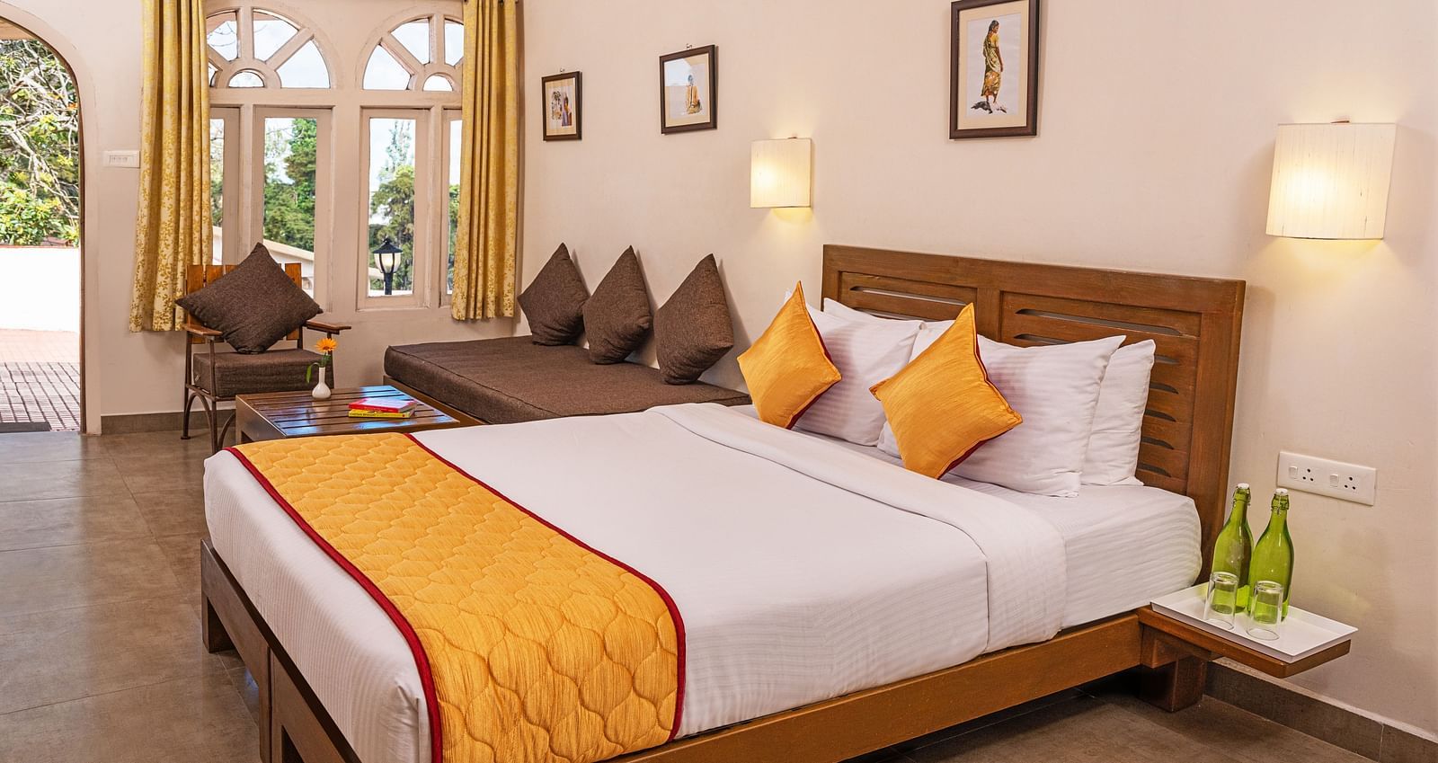 A large bedroom with double-size bed an a small sitting area beside it | Mango Hill, Kodaikanal