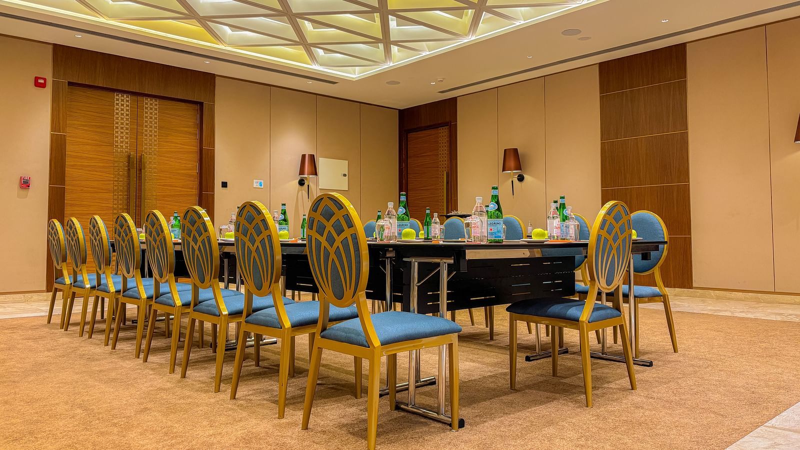 Banquet Hall at KertelSuites, featuring a long table with elegant chairs, complemented by a stylish ceiling and ambient lighting