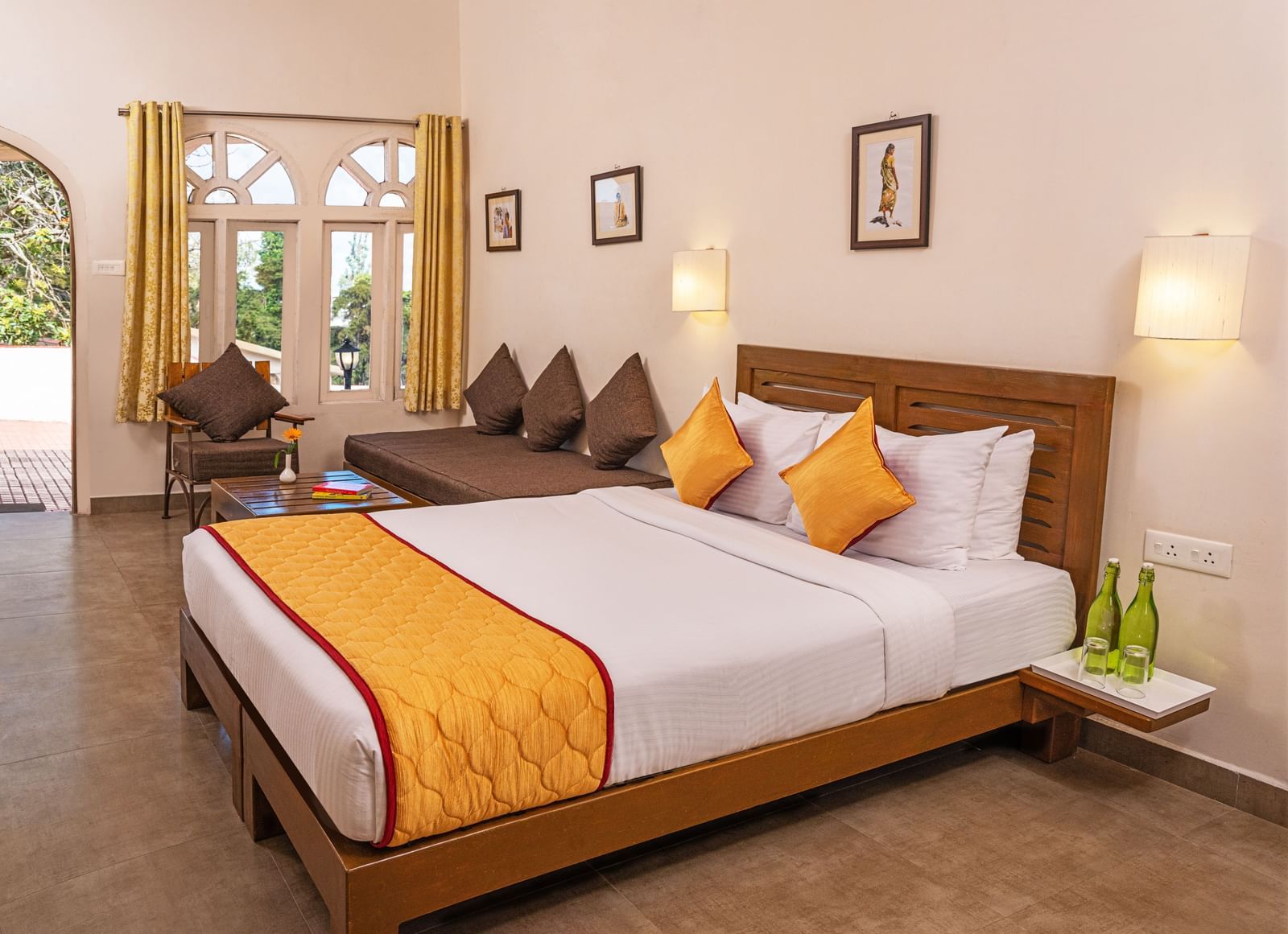 Premium room with a queen-size bed, orange bedding, and a sitting area by the window.