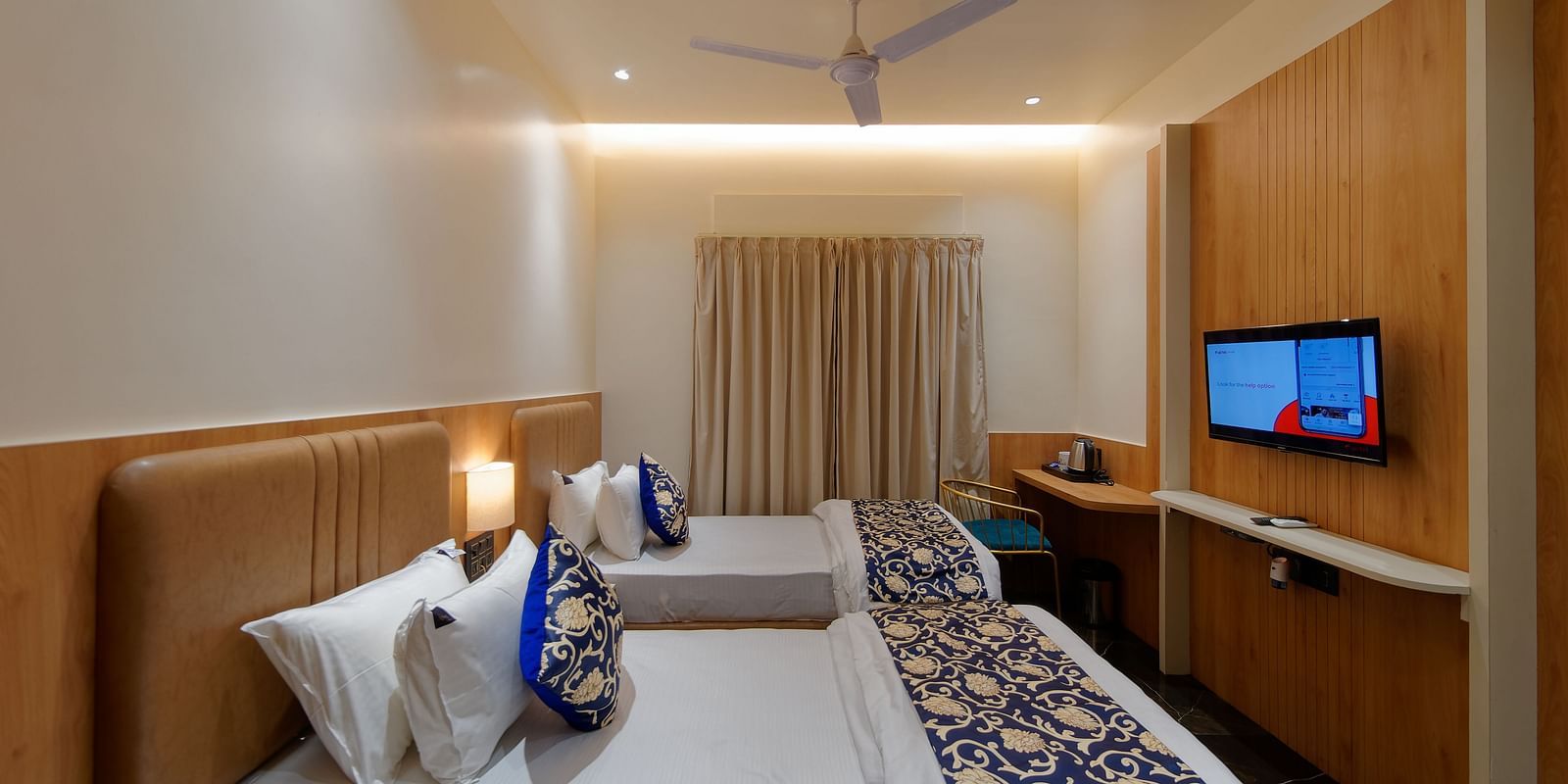 Image of deluxe twin room twin beds with a television in font and ceiling on the wall at Ankit Hotel, Jabalpur