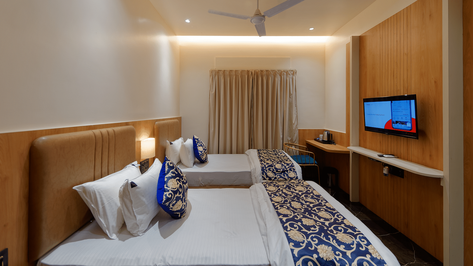 Twin beds and a television in a room at M Square Hotels & Resorts