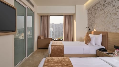 Spacious hotel room with two beds, city view, and modern amenities - Biznotel by Pride Motera, Ahmedabad