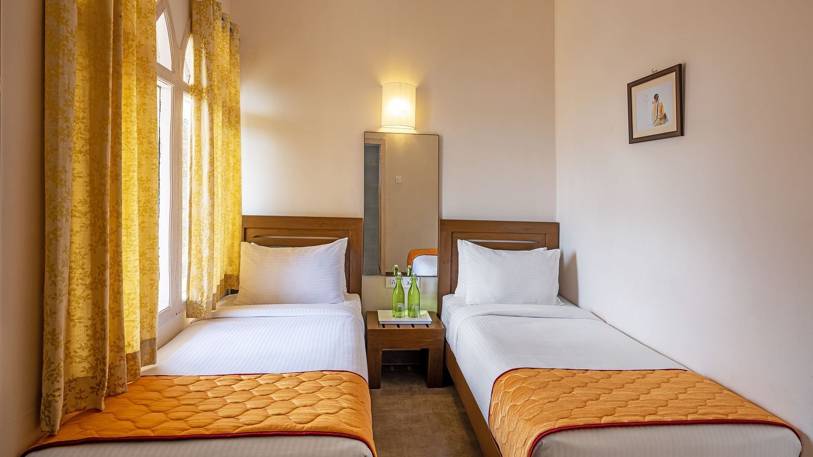 Villa bedroom with two twin beds and yellow curtains.
