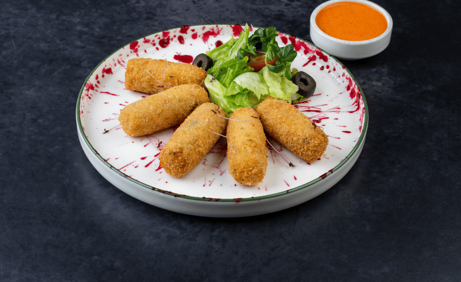 Tender Coco and Corn Croquettes served in a platter with sauce at The Wild Fork restaurant in La Marvella, Bengaluru.