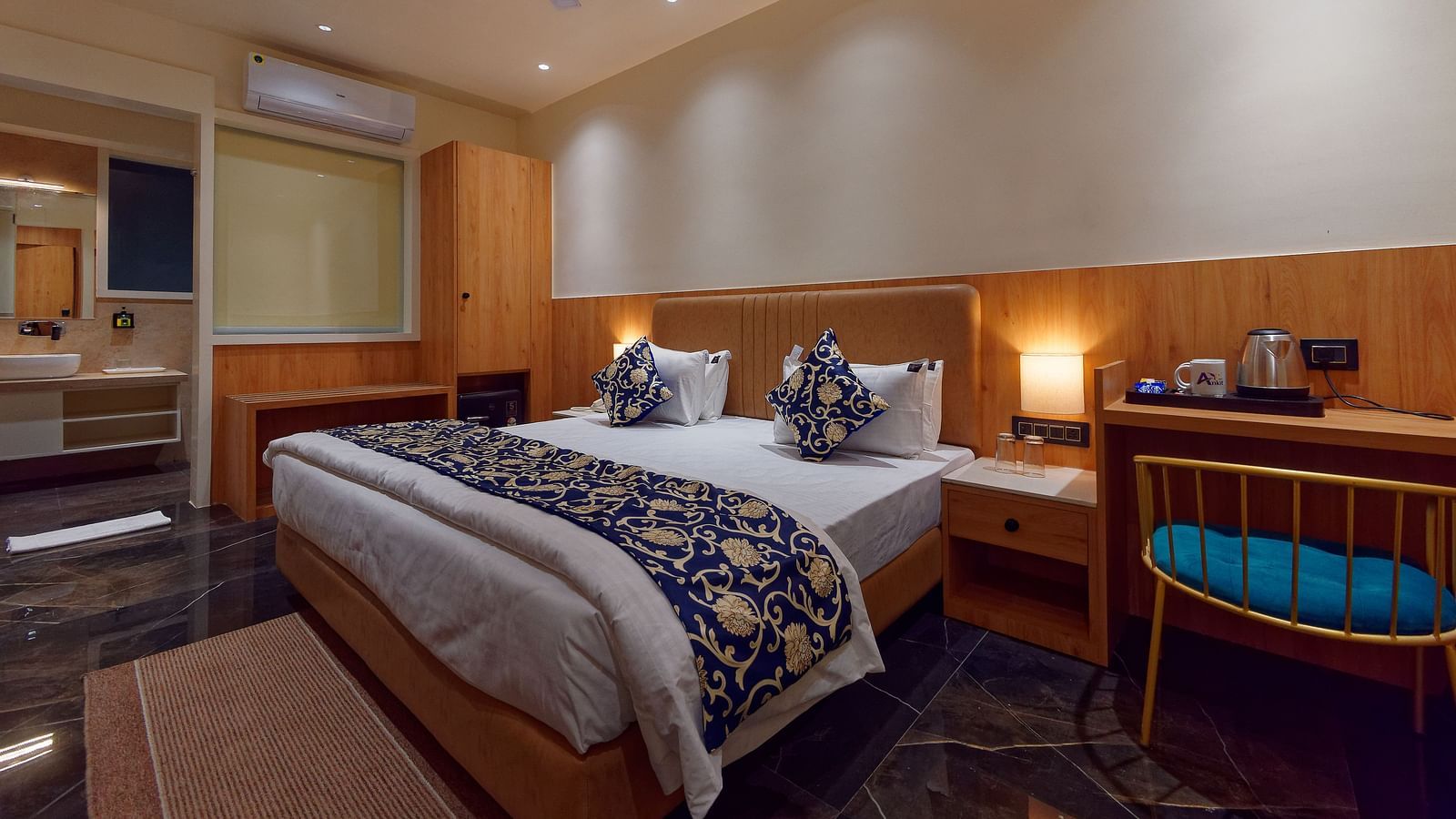 A double bed and a work desk and chair in a room at M Square Hotels & Resorts