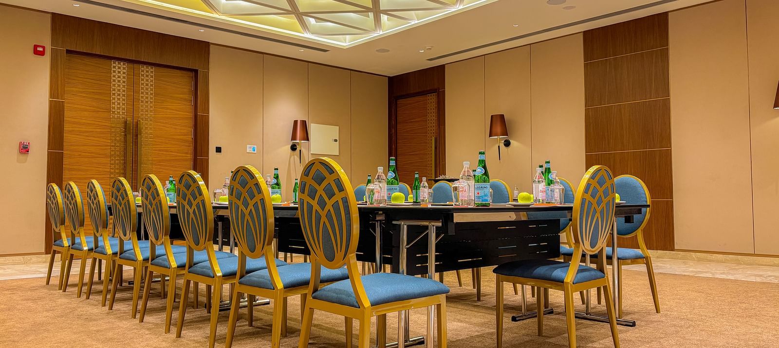 Banquet Hall at KertelSuites, featuring a long table with elegant chairs, complemented by a stylish ceiling and ambient lighting