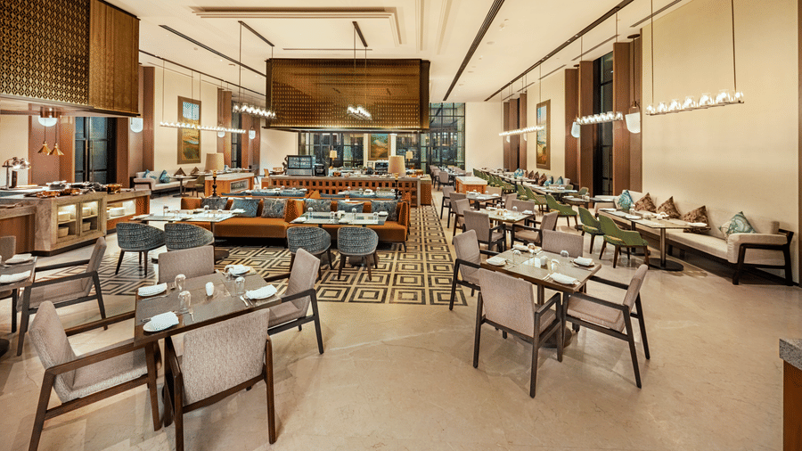 Restaurant seating area with wicker chairs and a bold patterned floor at Chithirai restaurant, The Residency Signature Madurai