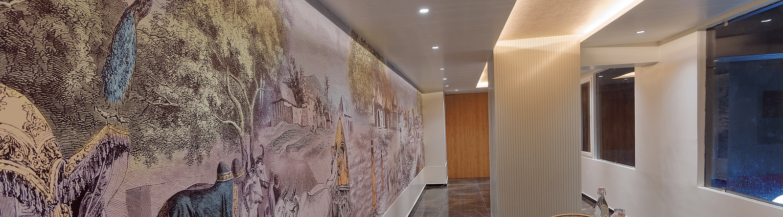 Image of seating area with chairs and tables and mural on the wall at Ankit Hotel, Jabalpur