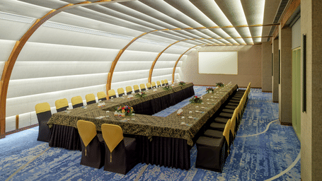 The Panorama hall at Swosti Premium Beach Resorts, Puri, with tables and chairs, featuring the signature curved ceiling and wall design of the event space.