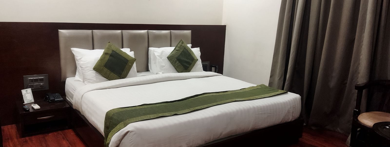 Another view of a hotel room with a green runner on the bed, a seating area - TGI Apple Inn, Jaipur 