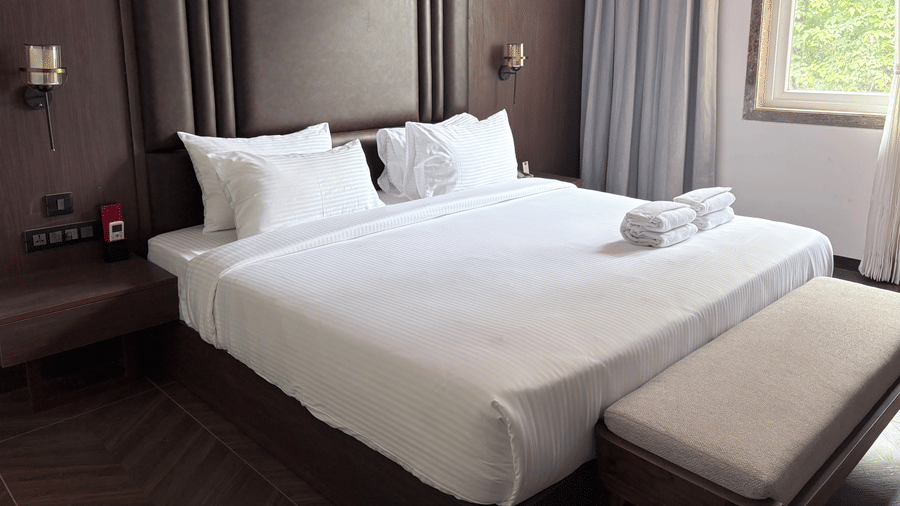 Side view of the bed showing the large window and natural light - Lords Riverside Resort, Muduba - Shivamogga