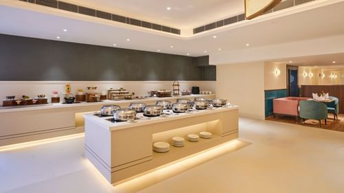 An image of a restaurant in Bhopal featuring a buffet table with an array of food displayed on the countertop at  Tulip Inn, Bhopal.